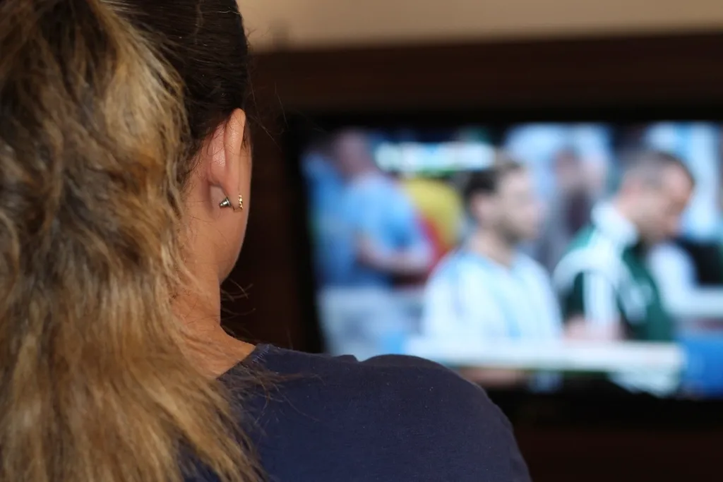 Person schaut ein Fußballspiel auf einem Fernseher